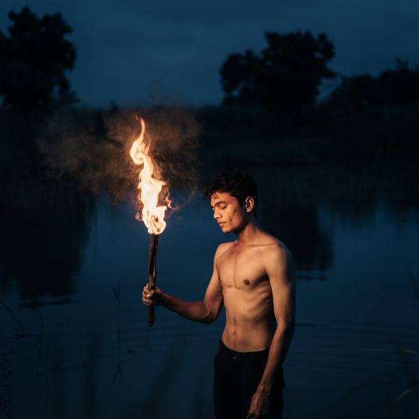 Silhouette of a person stretching against a dark background with a violet glow.