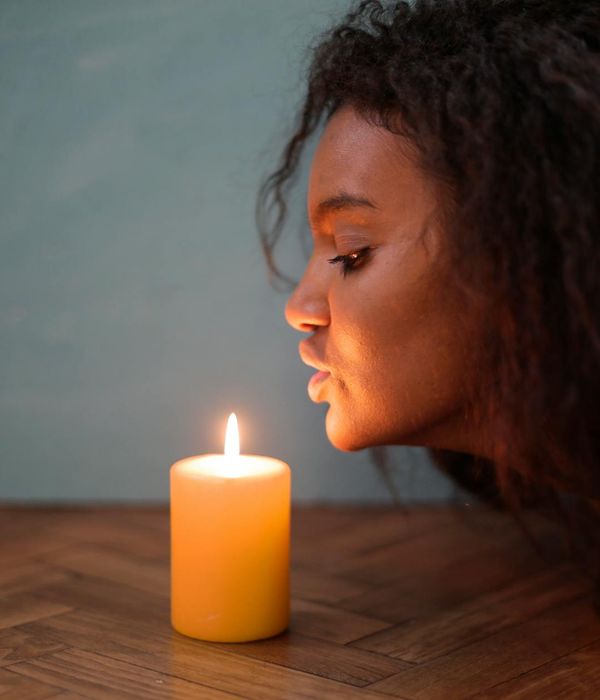 Woman in a peaceful meditation pose in a dark room with violet light.